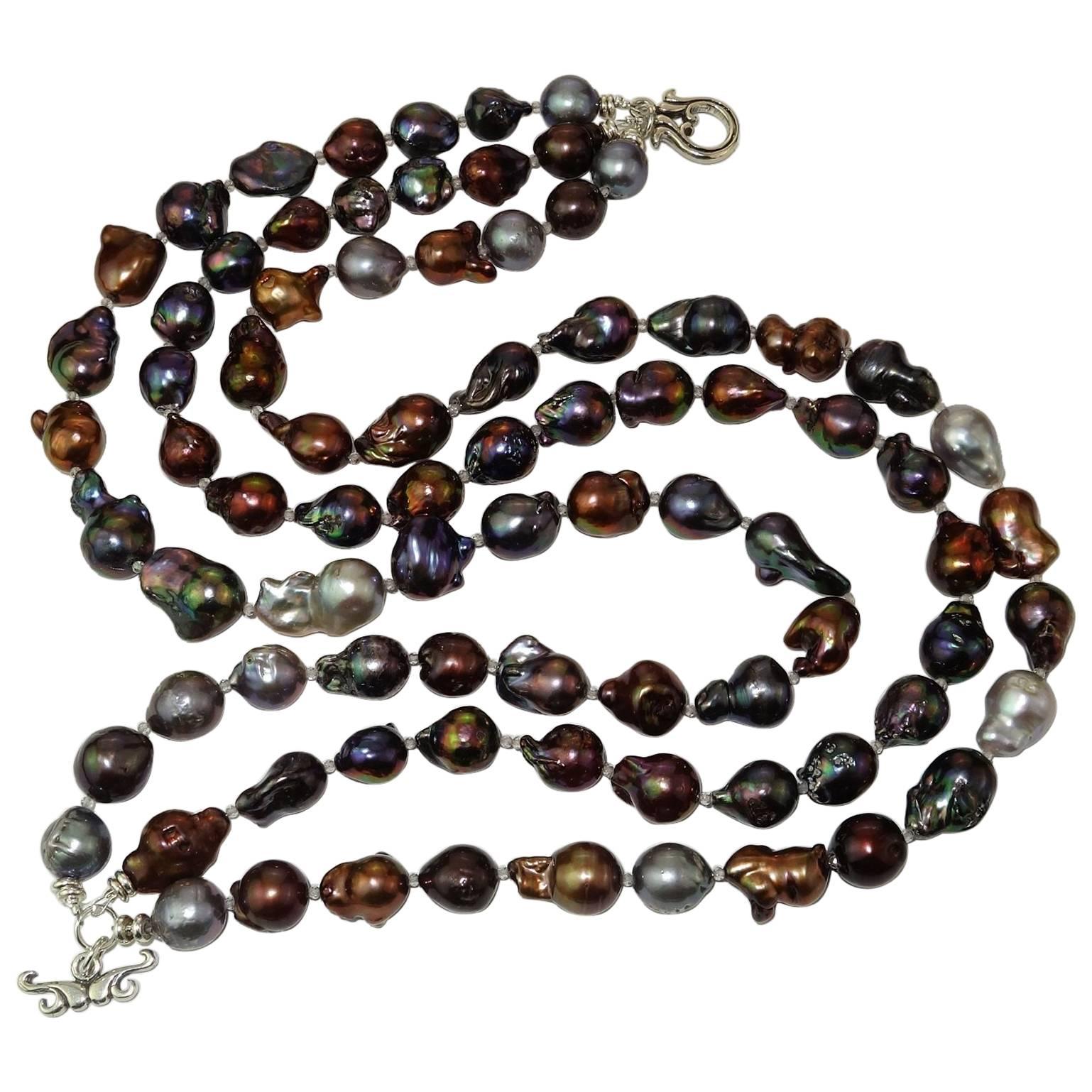 Custom made triple strand necklace of rich multi color Baroque pearls spaced with sparkling silver topaz accents. The baroque pearls range in color from gold to gray, mauve, bronze, and aubergine. The Baroque pearls have an interesting variety of
