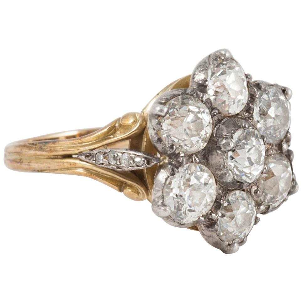 This superb antique ring is in excellent condition and a prime example of the fine hand made rings of the time. Set with 7 old cut mine diamonds of white sparkling colour.  The cluster is set to an exquisite trefoil shank with each centre piece of