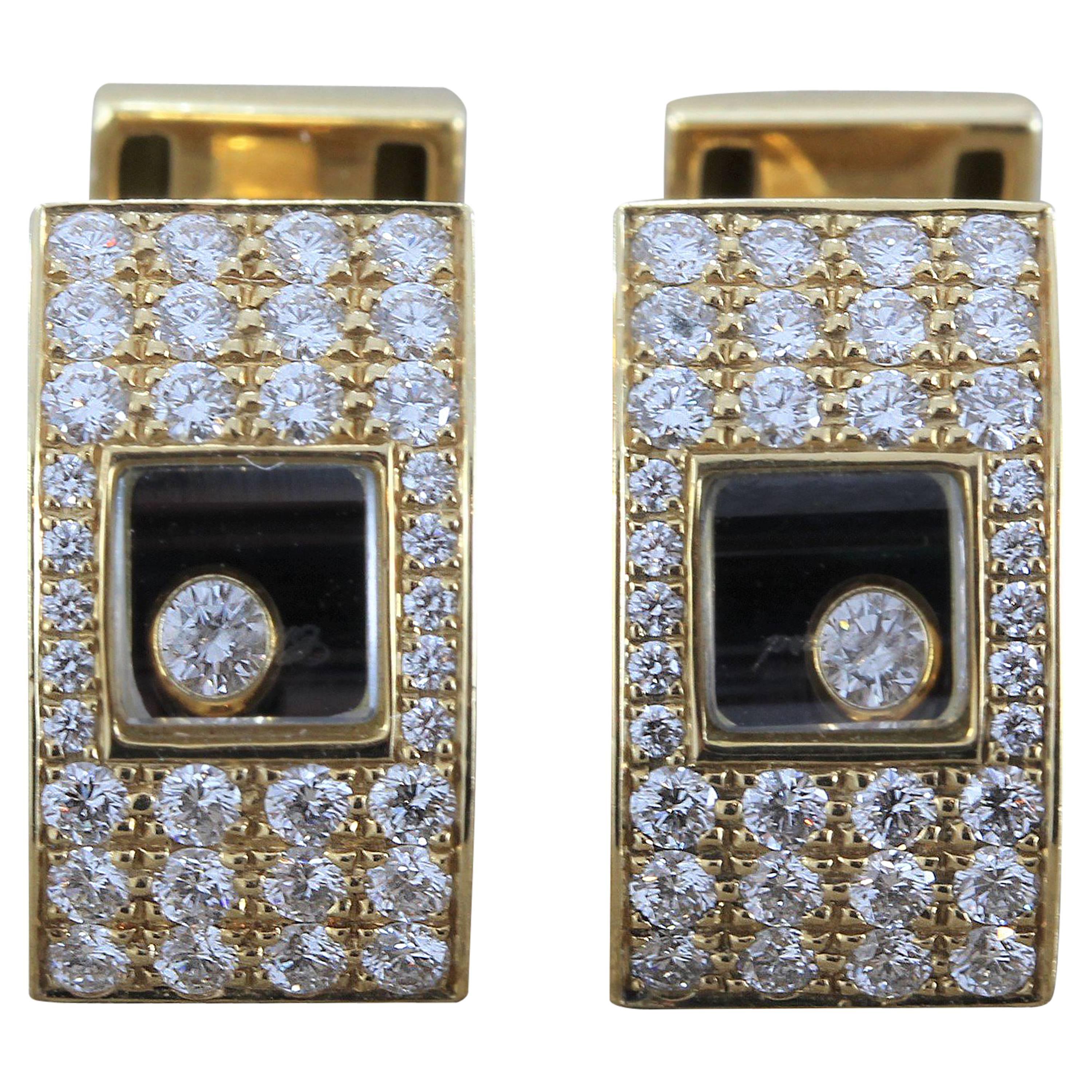 Chopard presents a pair of 18K yellow gold cufflinks featuring 1.25 carats of round cut diamonds bordering a glass frame with a single happy diamond inside.