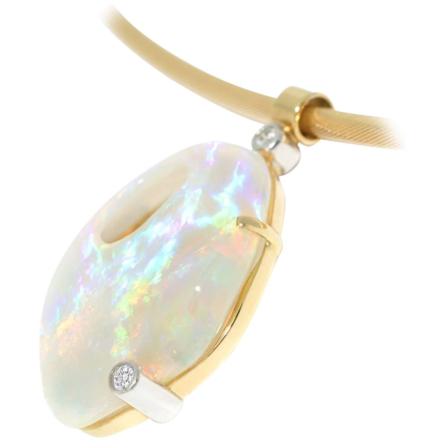 This gorgeous, one-of-a-kind Australian crystal opal necklace is handmade in 18k yellow gold and adorned with two brilliant cut white diamonds. The opal has a lovely, strong play of colour with blues, greens, oranges, yellows and purples. Suspended