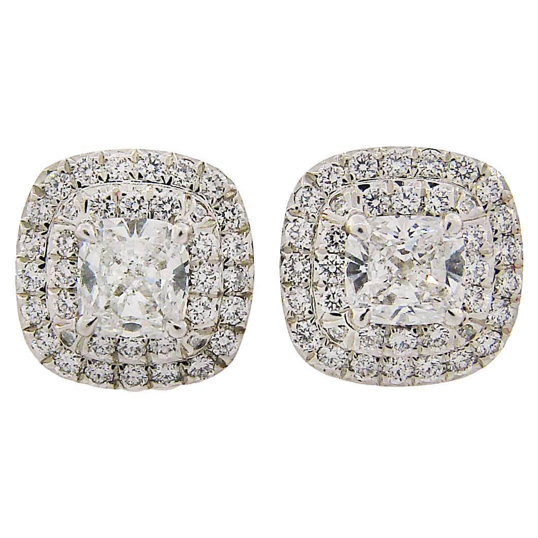 Lovely diamond stud earrings that is a must in every woman jewelry collection. Created by Tiffany & Co., the earrings feature a cushion cut diamond framed with two rows of round brilliant cut diamonds. The settings are made of platinum. The