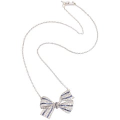 Art Deco Calibre Cut Sapphire with Diamonds, Platinum Crinkly Bow Pendant