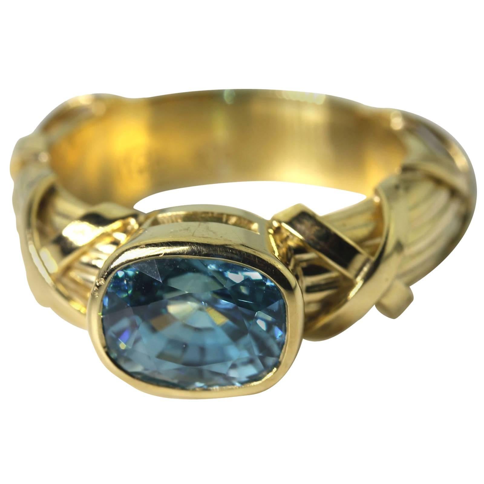 Glittering flashing 4 carat blue Zircon set in a unique handmade 18 karat yellow gold ring size 7 (sizable for free). The ring is sizable. 