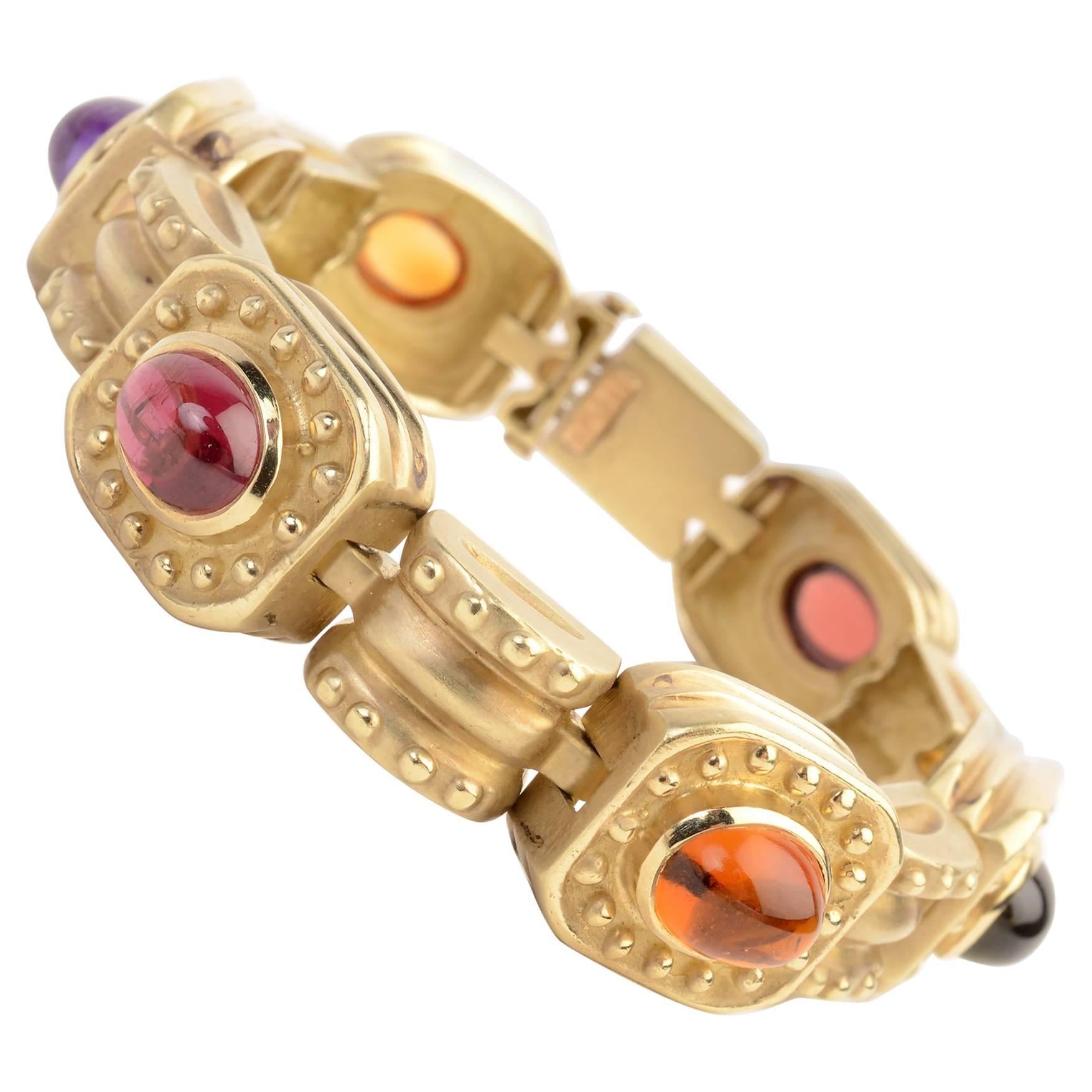 Eighteen karat gold bracelet by SeidenGang with 6 plaques, each with a cabochon stone. They are amethyst; citrine; rubelite and tourmaline.  Arched links between the stones continue the raised circles pattern of the gold. The bracelet is 7 inches in