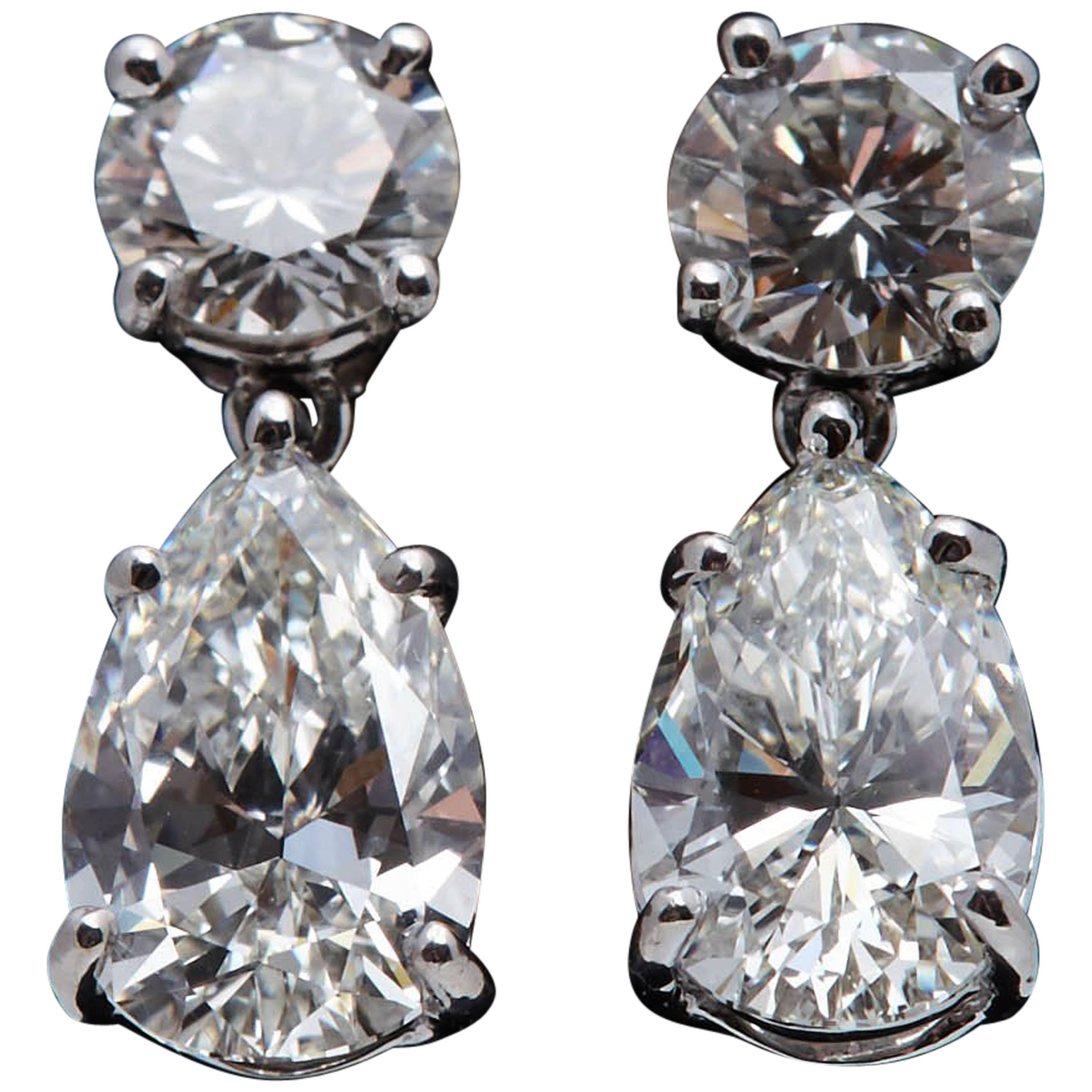 3.08 Carat Dangling GIA Pear Shaped Platinum Earrings with Two Round Diamonds For Sale