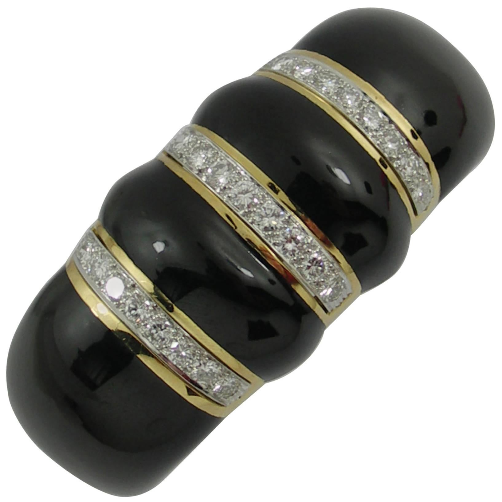 A rounded 18K yellow gold cuff bracelet, with a bombe design accented with black enamel, and set with diamonds. With 24 round brilliant cut diamonds set into platinum strips, this important piece has sparkle as well as substance. The diamonds weigh