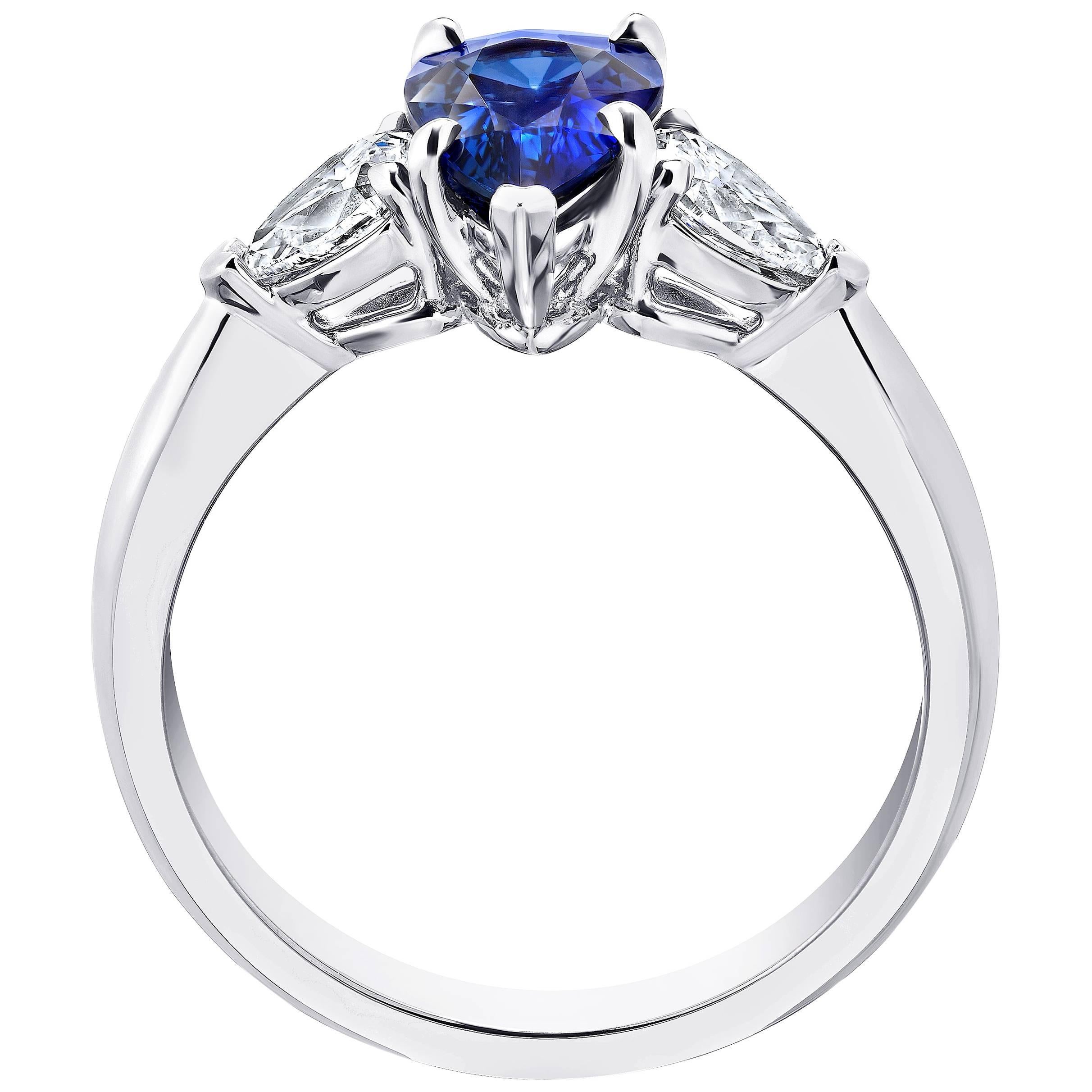 This blue sapphire ring is impeccable. Its center stone is a pear shape blue sapphire weighing 1.61 carats. The stone is perfectly cut and extremely clean with great  color saturation. Two pear shape diamonds weighing .56 carats (F+ VS+)  seamlessly