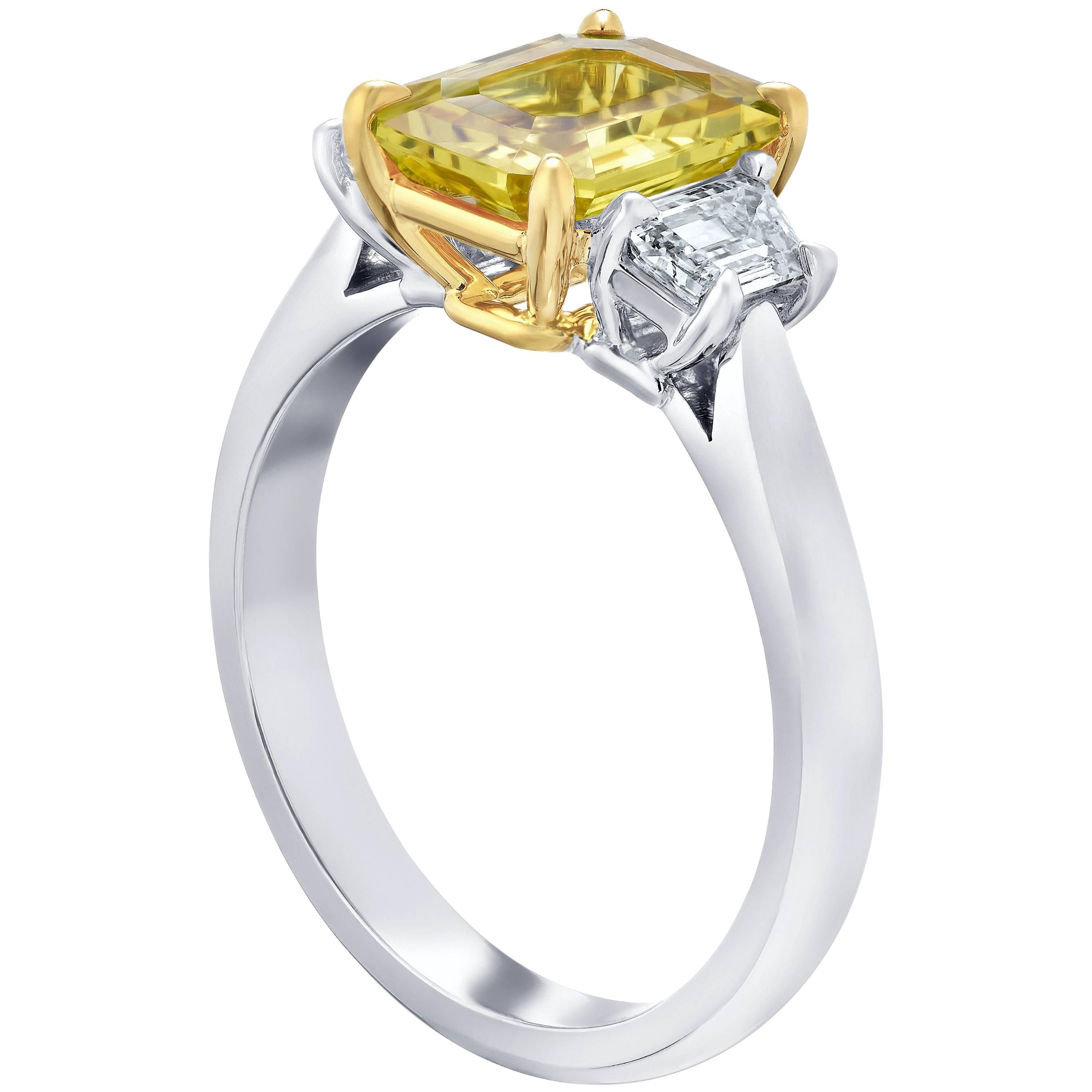 This meticulously crafted ring has a center Emerald Cut Yellow Sapphire weighing 2.50 carats with two trappazoid diamonds (F+ VS1+) weighing  .58 carats. All set in platinum and 18k yellow gold basket.
The center stone is total clean and has a great