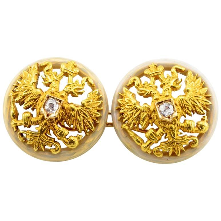 A pair of Fabergé diamond-set gold and enamel Imperial presentation cufflinks, Saint Petersburg, 1899-1904. Both links formed as a pierced and engraved gold Imperial eagle centered with an Old European cut diamond in a shield-shaped mount, set on a