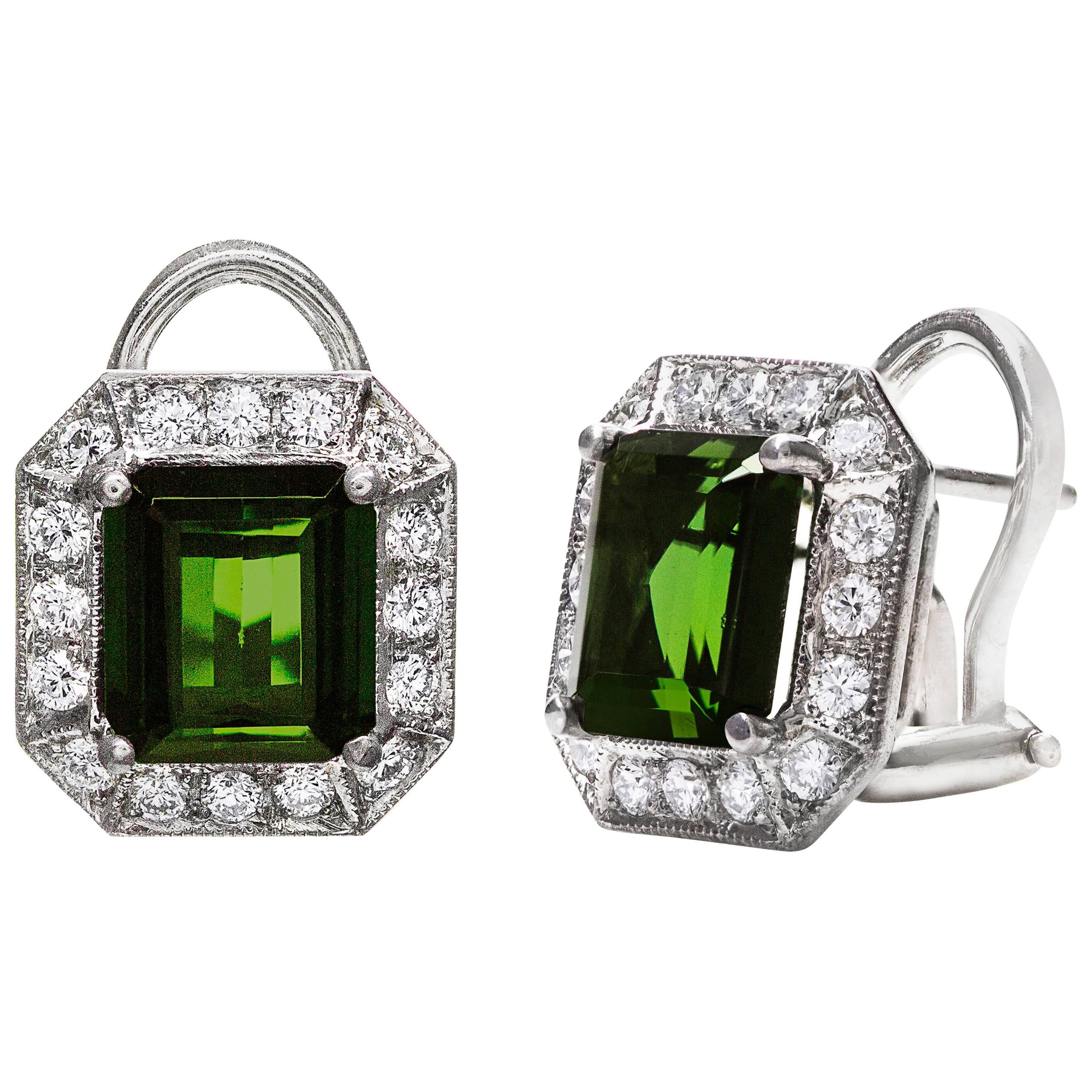 A gorgeous pair of earrings showcasing two emerald cut green tourmaline weighing 3.63 carats total, set in a classic four prong setting. Surrounded by a row of round brilliant diamond weighing 0.40 carats total. Finished with milgrain edges. Finely