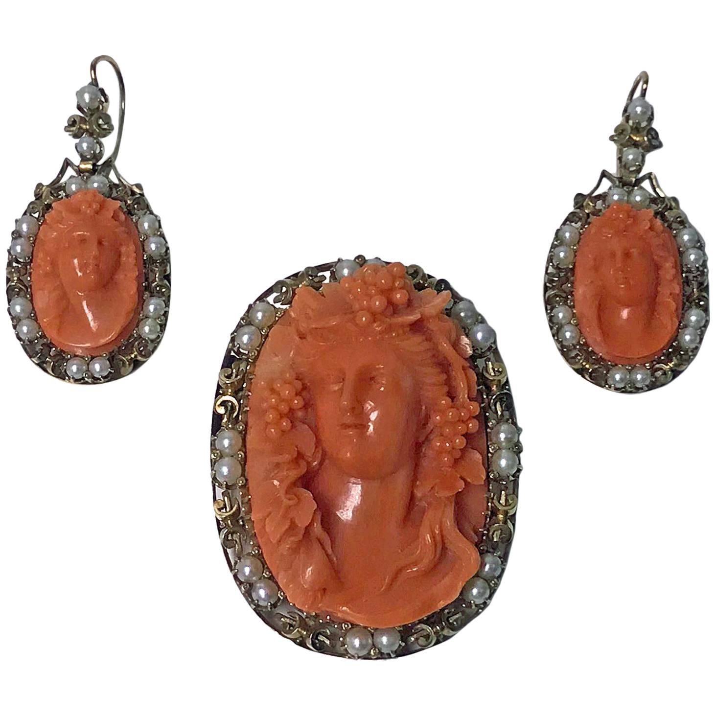 Very rare and fine 19th century oval Coral Corallium Rubrum Pendant Brooch and matching Earrings, C.1880. The set depicting carved Bacchante. The intricately carved openwork gold (tested as 14K) mounts each interspaced with fourteen silver white