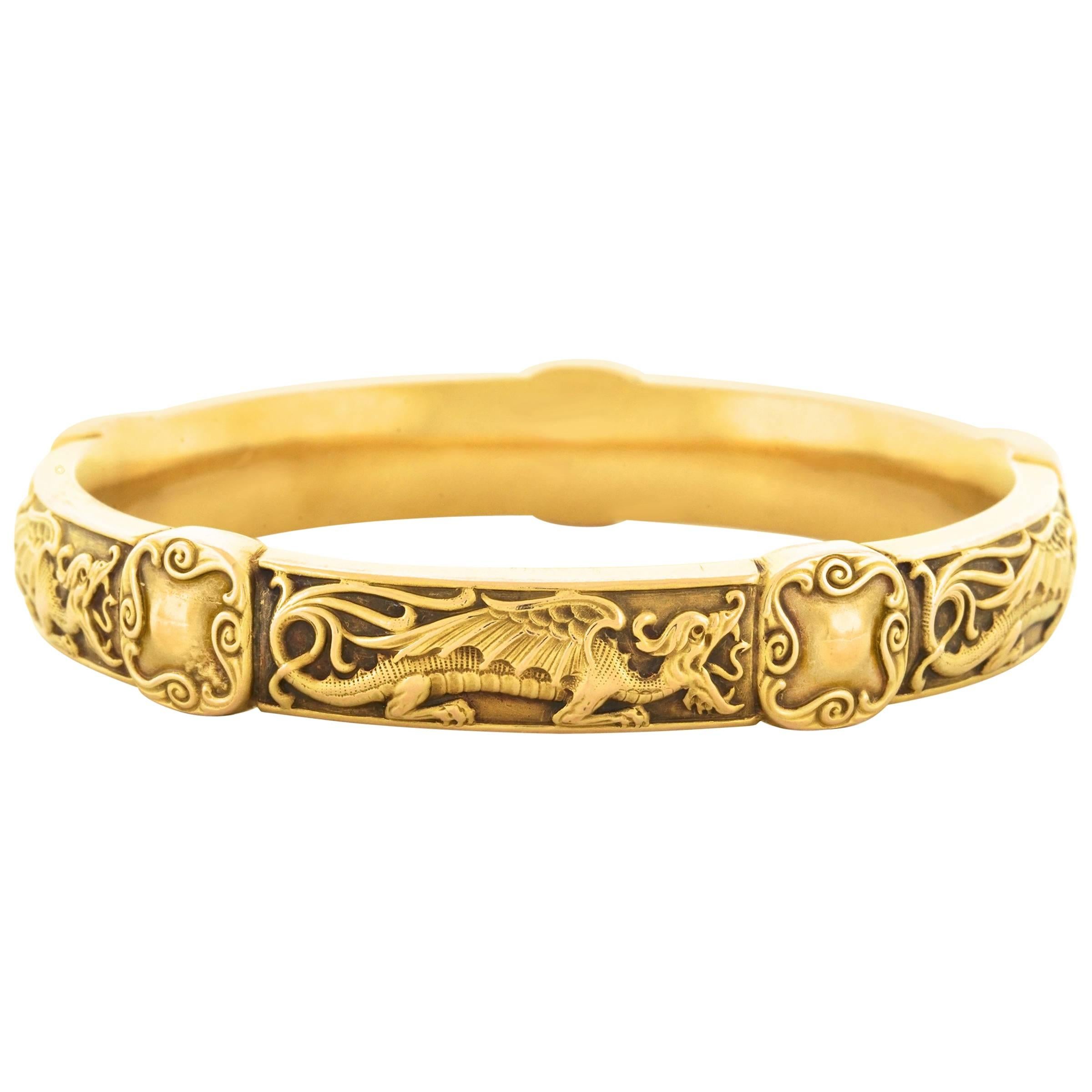 Circa 1890s, 14k and 18k, by Riker Brothers, American.  This stunning pair of Art Nouveau bangles in the Japanese taste by Riker Brothers features a detailed dragon motif and a rare diamond-set Imperial chrysanthemum design. Delightfully