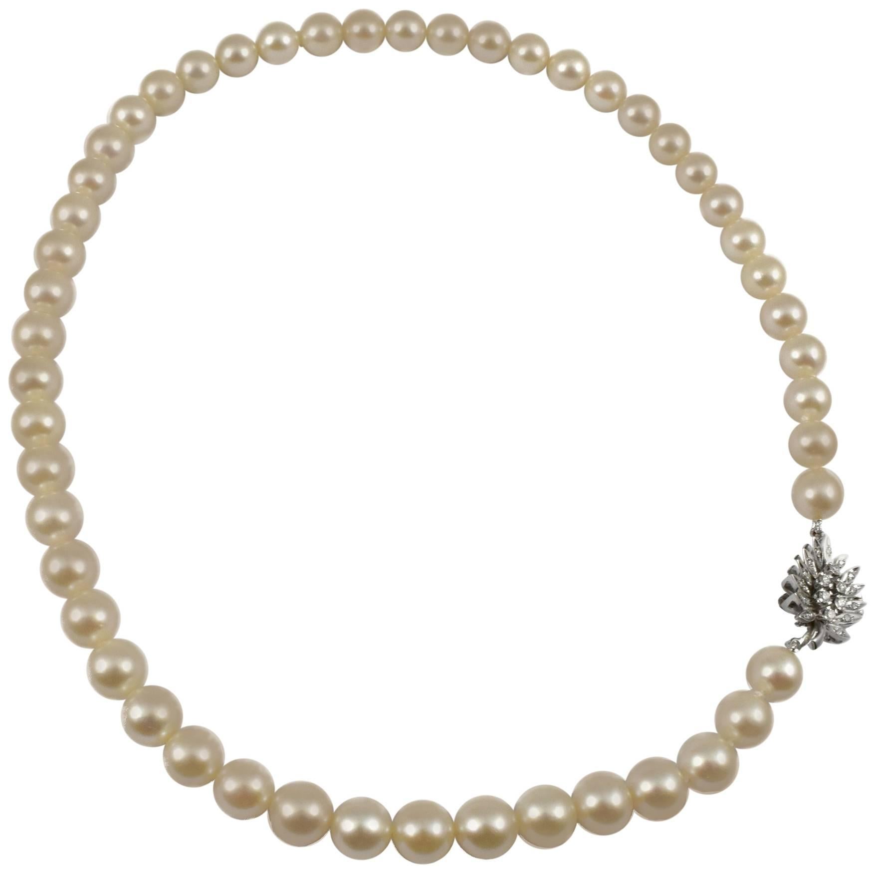 A Pearl necklace with a handmade Diamond White Gold Leaf design clasp. The solid 18 karat gold clasp is handmade in detail with a safety catch and set with diamonds. The pearls are single strand 9mm saltwater white with Ivory overtone, Princess