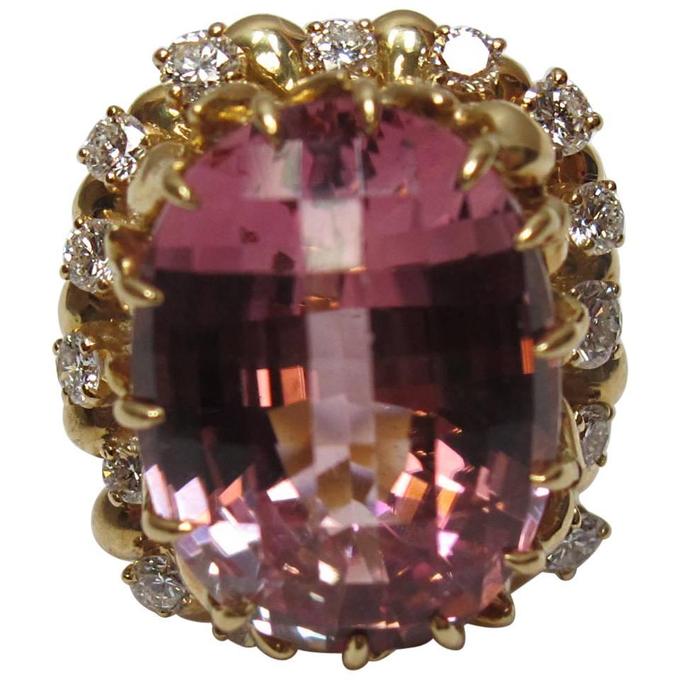 Pink tourmaline ring by Julius Cohen. Size 6, set in 18kt yellow gold with diamonds. Tourmaline is oval checkerboard cut and 16 cts, and the ring has approx. 1 ct total weight in round diamonds. Diamonds are VS clarity/ EFG Color. 