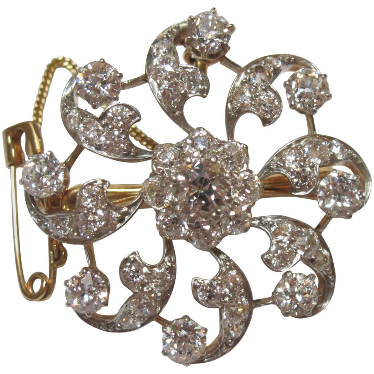 Diamond pin set in both platinum and yellow gold. Diamonds are Old European Cut and Transitional Cut, weighing a total of 5.6 carats. Center stone weighs 0.8-0.85 cts and is FG color, SI2 clarity . Surrounding stones range from .04-.30 cts each, all