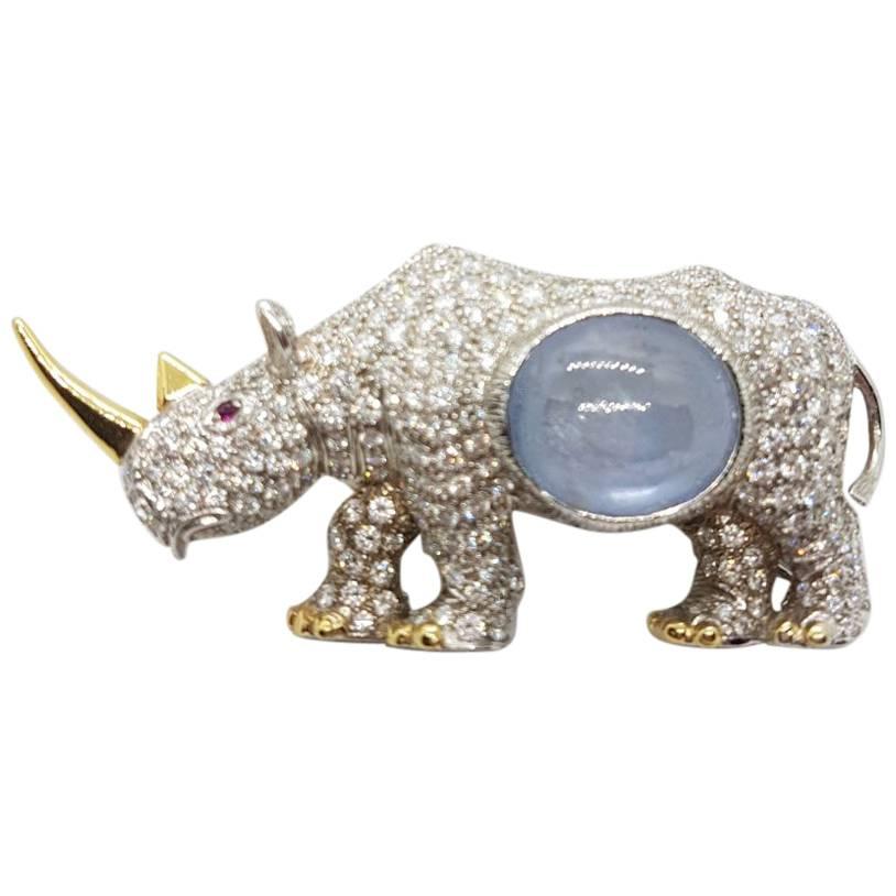 Rhinoceros Broach in White and Yellow Gold with Diamonds and a Sapphire Cabochon For Sale