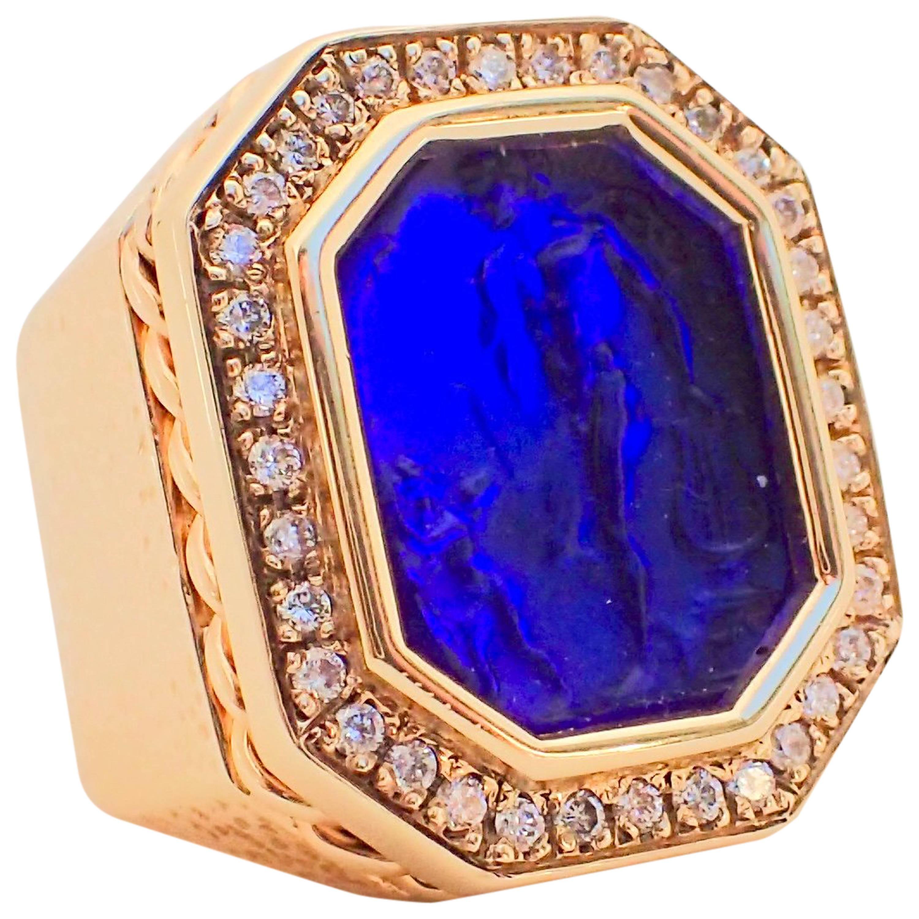 One (1) 14k yellow gold ring has a hammered texture, braided wire crown, one (1) blue intaglio and thirty-six (36) Round Brilliant Cut diamonds surrounding the intaglio, that weigh a total of 0.43 carats, that measure 1.35 x 1.35 mm, with Clarity