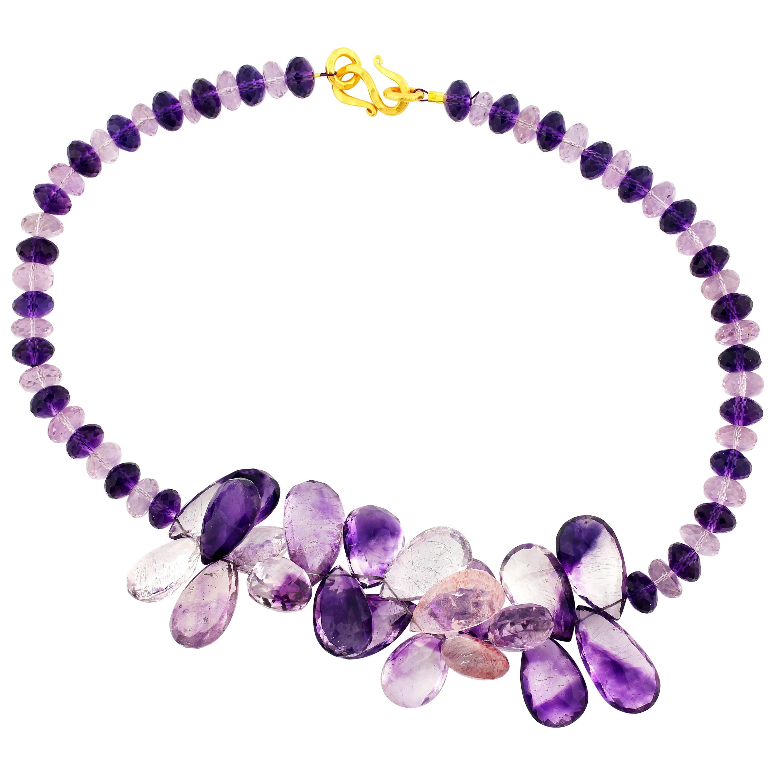 Glittering huge petals of checkerboard gem cut Amethysts (27.4 mm x 14.7 mm being the longest)  pinky/purple-y/mixed colors all translucent set with a hammered Vermeil (gold plated sterling silver) clasp. It looks wonderful which ever way you wear