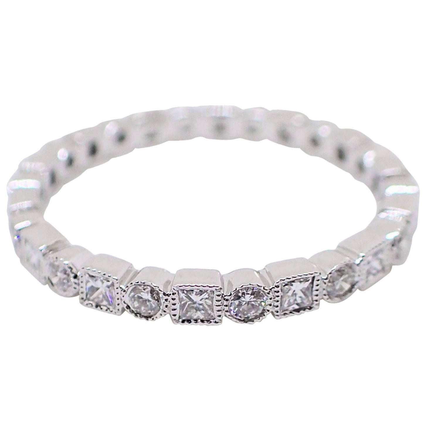 18k white gold eternity band is bezel bezel set with fourteen (14) Round Brilliant Cut diamonds that weigh a total of 0.26 carats with Clarity Grade VS-SI and Color Grade G and fourteen (14) Princess Cut diamonds that weigh a total of 0.38 carats