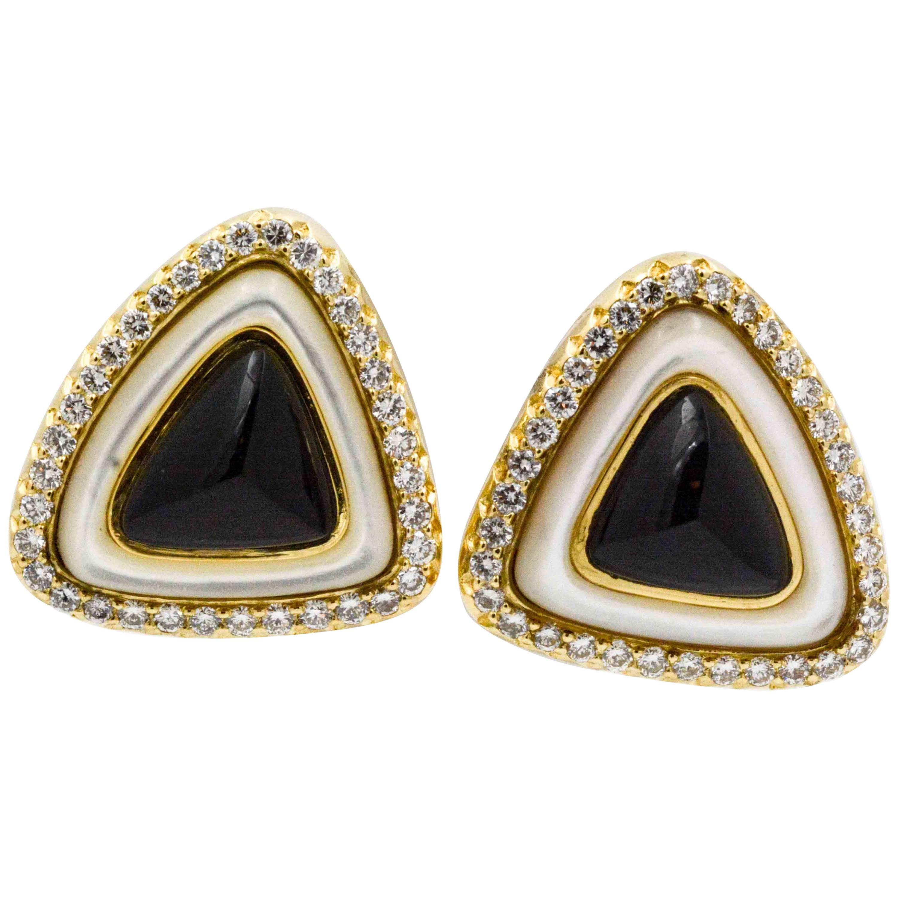 Timeless triangle cabochon cut black onyx meets crisp white Mother-of-Pearl which are surrounded by 70 dazzling round brilliant cut diamonds set in 18 karat yellow gold earrings. These exquisite earrings are stamped 
