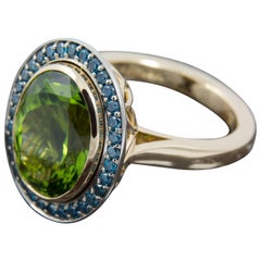 8.35 Carat Peridot and Blue Diamond Halo Cocktail Ring set in 18 Karat Gold