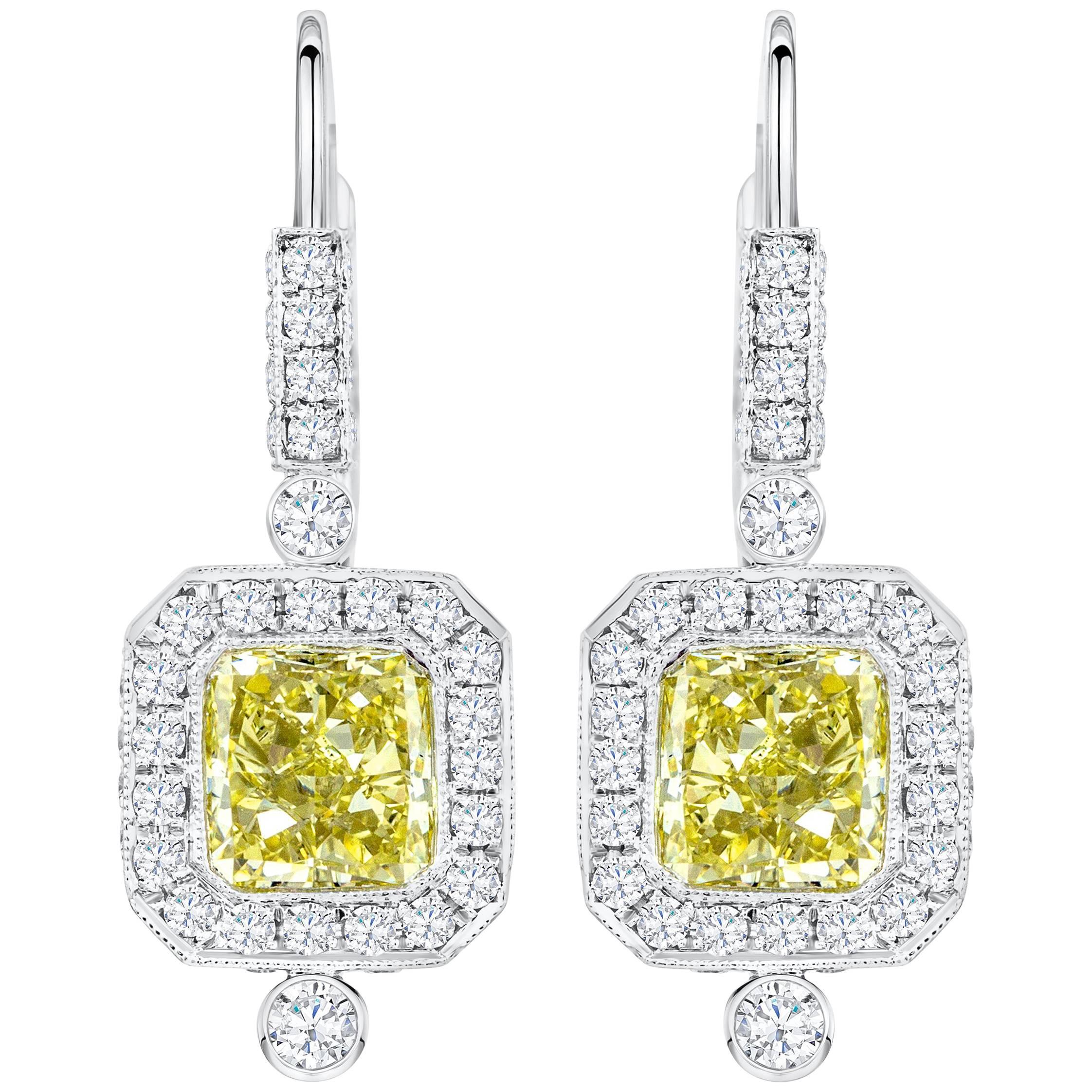 An antique style design dangle earrings showcasing two perfectly matched GIA Certified Radiant Cut diamonds weighing 3.04 carats total, VS1-SI1 in Clarity. Surrounded by round diamond in a halo design, Made in Platinum

Roman Malakov is a custom