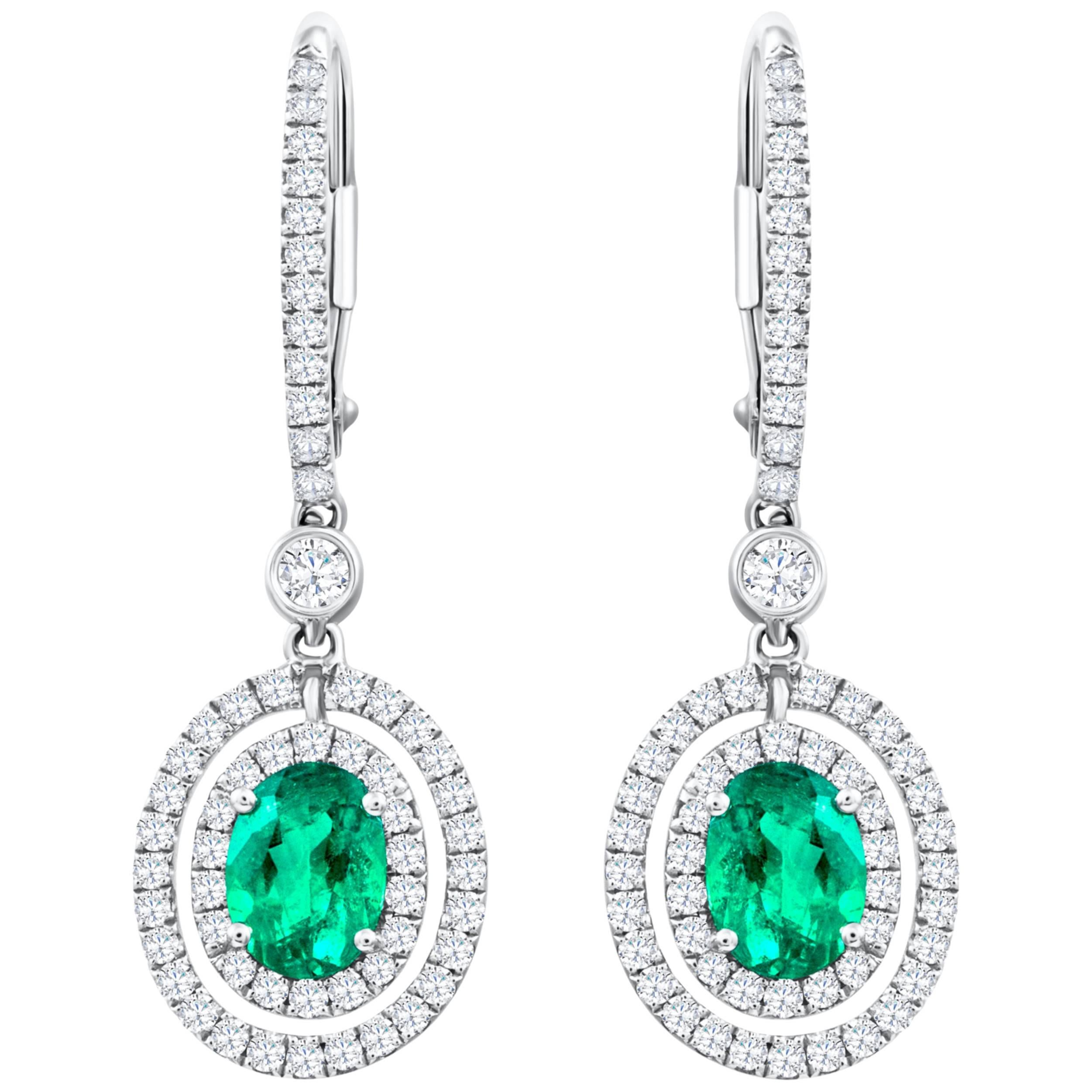 1.01 Carats Total Oval Cut Emerald and Diamond Halo Dangle Earrings For Sale