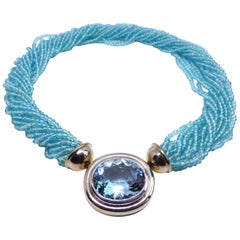 Collier en or blanc avec 1 aigue-marine et 1 pompon en apatite. 