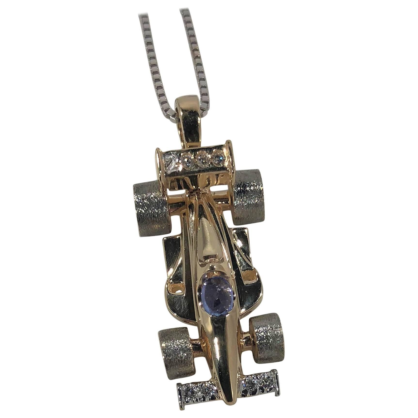 Mark Schneider Limited edition 14 karat yellow gold, diamond and Tanzanite Indy  car pendant. This is a limited creation by Mark Scneider the piece is marked 1/20 created. This piece is 14 karat yellow gold.The tires move  freely and  spin in the