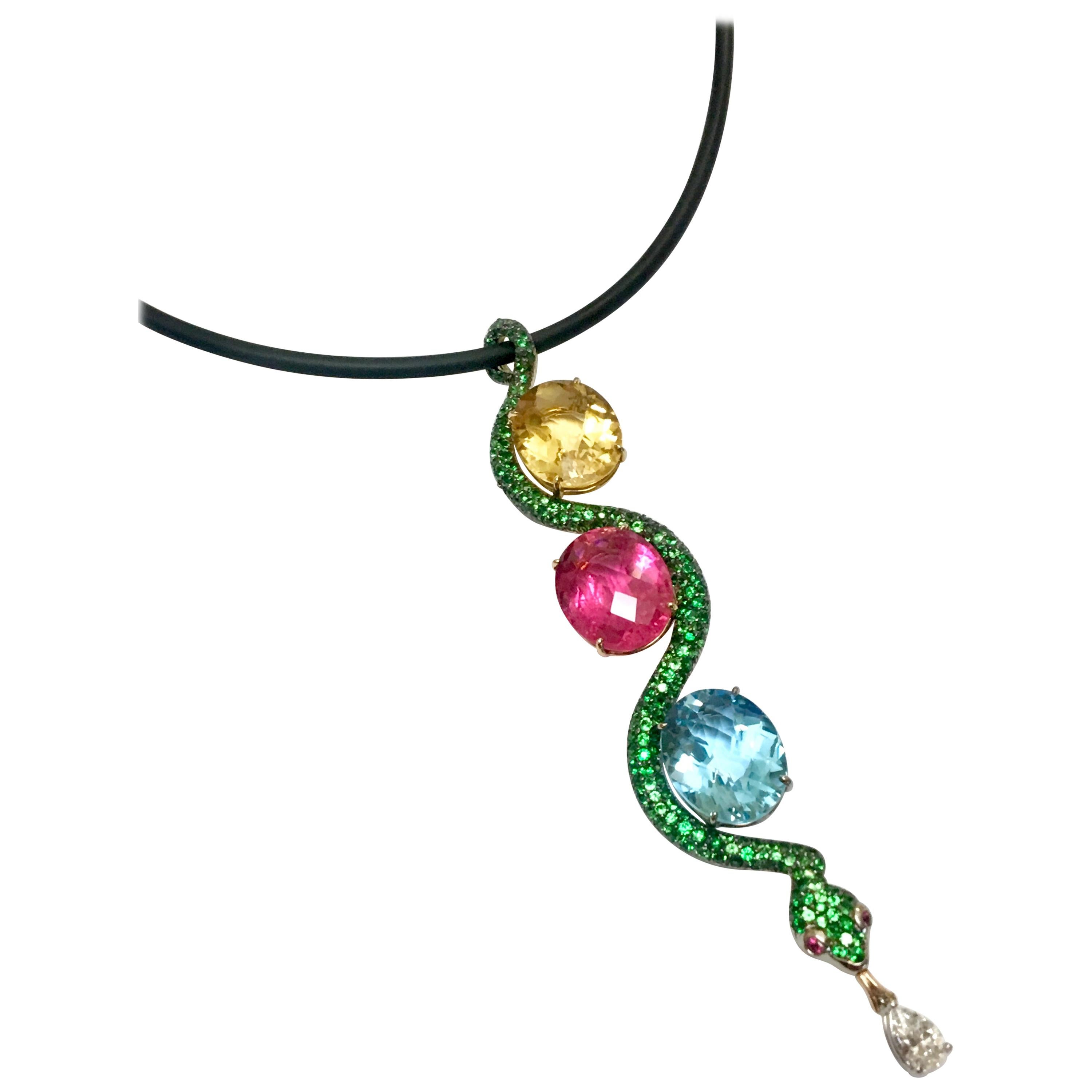 This exquisitely designed snake pendant uniquely combines a 9.28ct. Citrine, a 11.49 ct Rubellite and a 12.60 ct. Blue Topaz, all of gem quality, with 2.57 carats of Tsavorite garnet pave and a .46 carat diamond dangling. It is hanging on a black