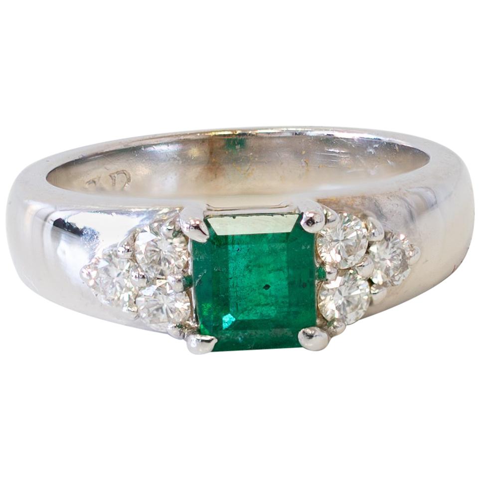 Ring aus 18 Karat Weißgold mit Smaragd im Prinzessinnenschliff in der Mitte und seitlichen Diamanten im Angebot