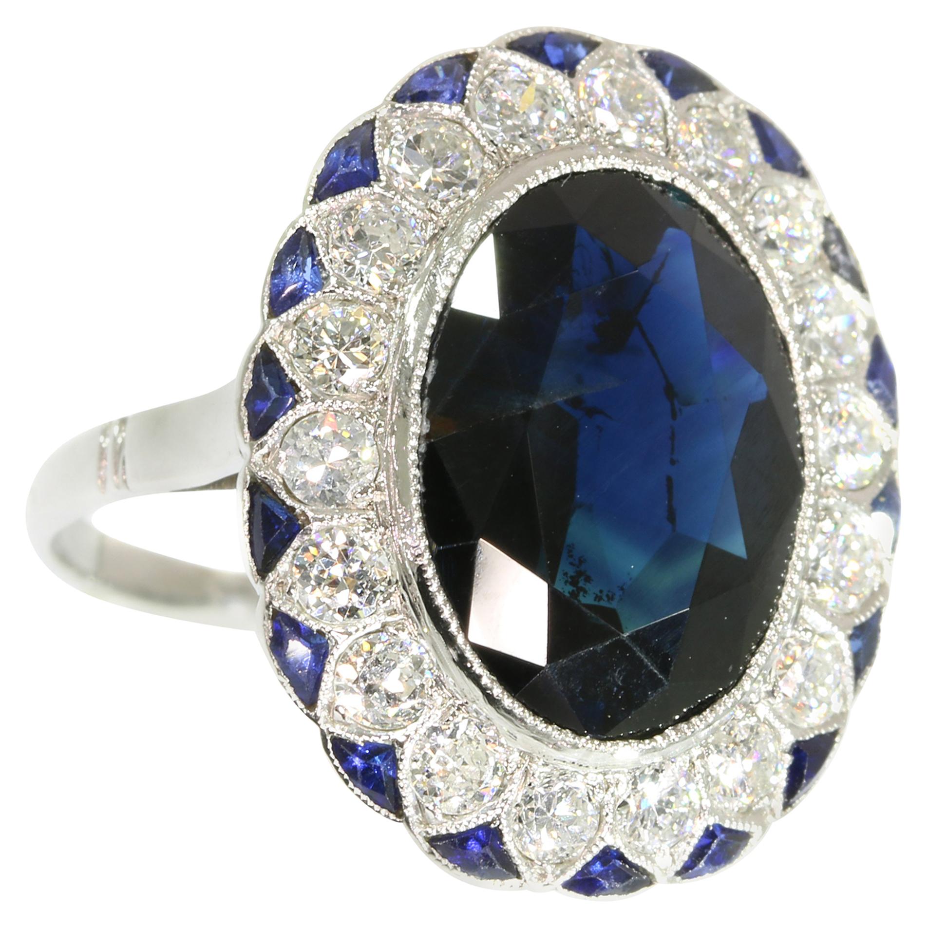 From the first glance, it’s clear that this Art Deco platinum engagement ring from 1920 emanates nobility. In resemblance of the Lady Di ring, the deep blue of a natural oval cut sapphire springs from between 18 surrounding old European cut diamonds