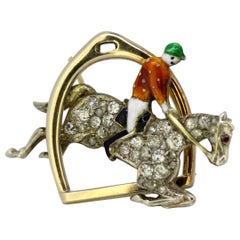 Art Deco 18k gold horserider brooch decorated with enamel, diamonds and a ruby.