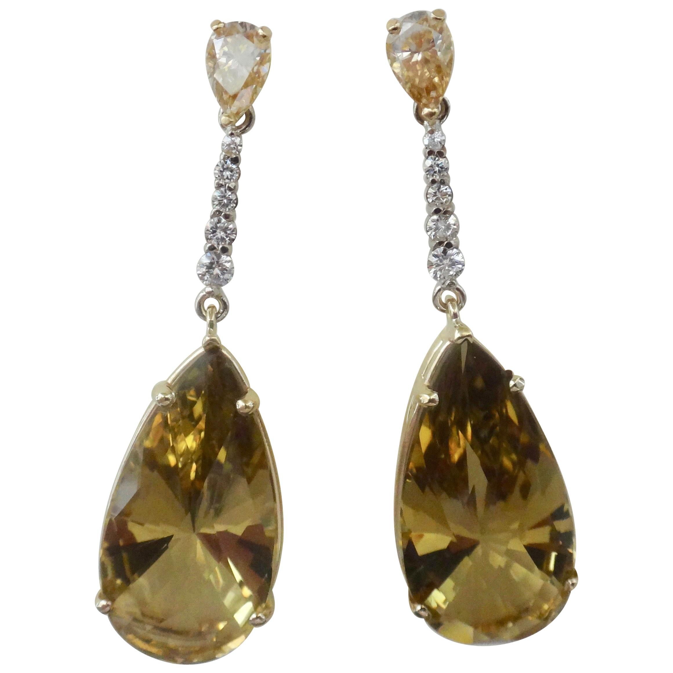 Perfectly matched pear shaped golden zircons (origin: Sri Lanka) begin the journey in these dangle earrings.  There are five graduated white diamonds set in white gold that lead to a beautifully cut and matched pair of lemon citrines with intense