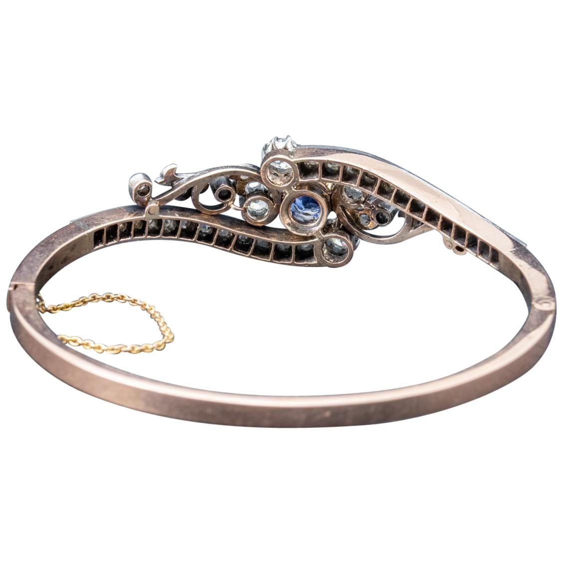 A magnificent antique French bangle from the early 20th century showcasing a stunning front gallery decorated with superb quality old cut Diamonds with a 1.36ct Sapphire in the centre haloed by larger old cuts. The four larger Diamonds are approx.