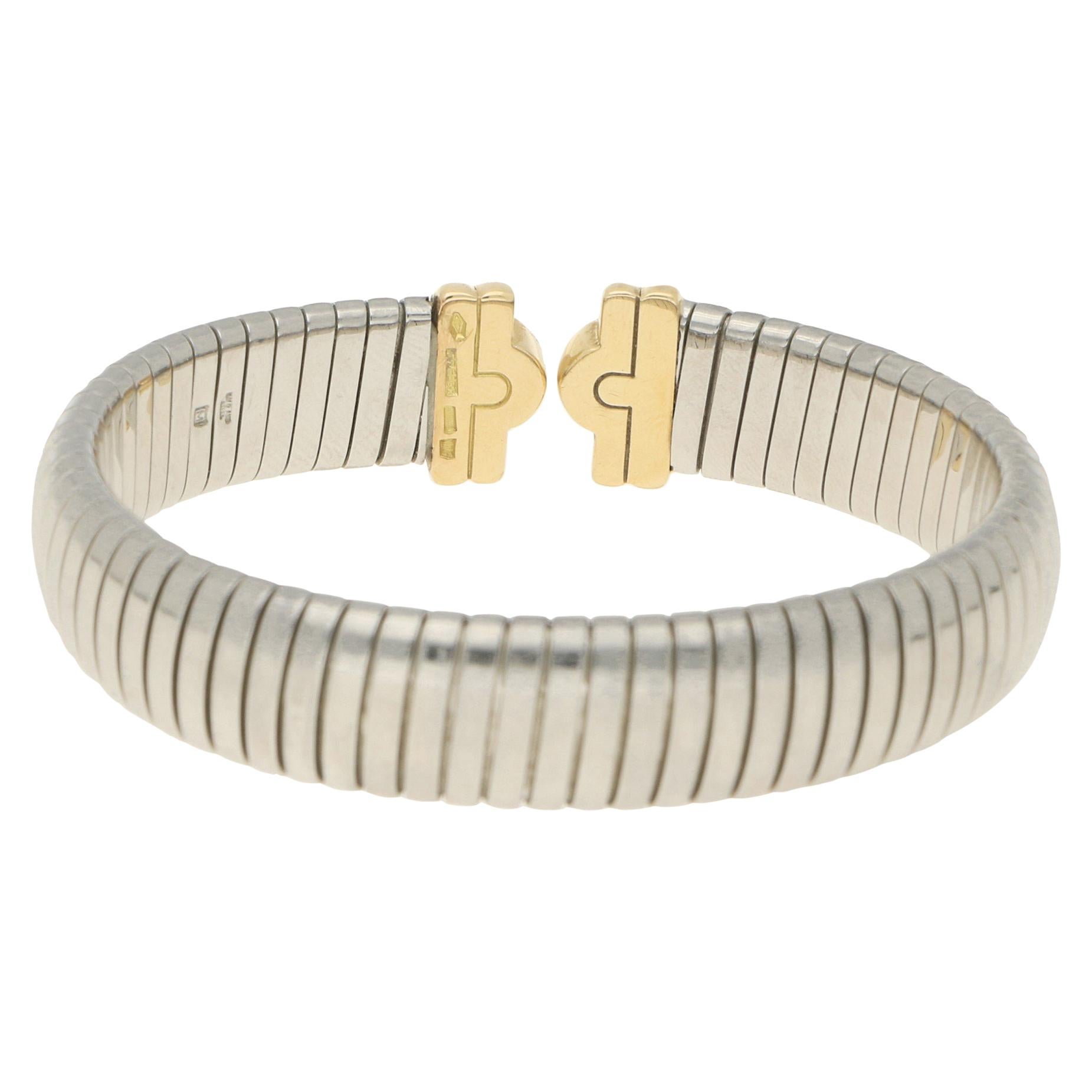 A vintage Bvlgari Parentesi diamond bangle bracelet in 18-karat yellow gold and stainless steel. From the brand's Parentesi collection, the bracelet is designed as a springy flat snake-link stainless steel bangle with Tubogas inspiration, leading to