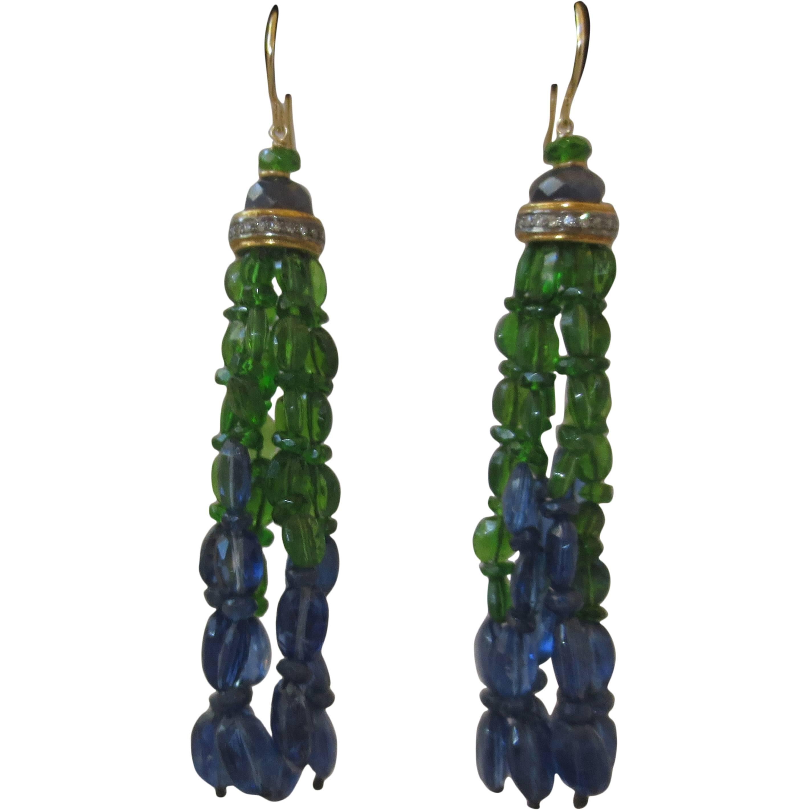 This beautiful kyanite, sapphire, and tsavorite tassel earrings with 14 k yellow gold are made by Marina J.. Topped by one tsavorite and one sapphire bead, placed over a silver, gold, and diamond-encrusted roundel. The tassel's strands exit the