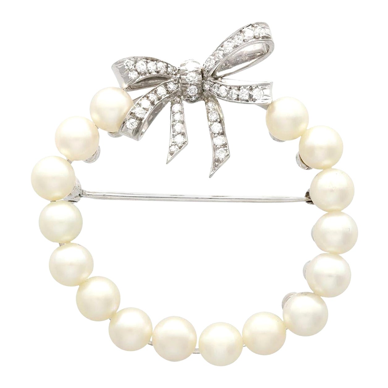Broche vintage en or blanc avec couronne de perles et nœud de diamants