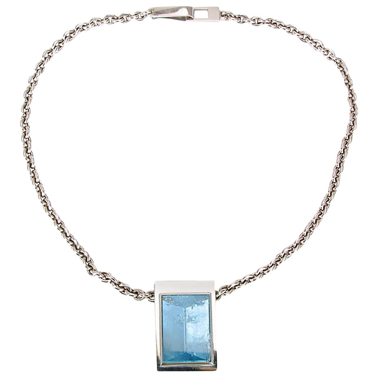 This marvelous aquamarine 63.04 ct adorns this 18k white gold necklace which is 51.5 cm long. The pendant is 4.2 cm long and 2.8 cm wide. This aquamarine has a very special mirror cut.
Designed by Colleen B. Rosenblat.