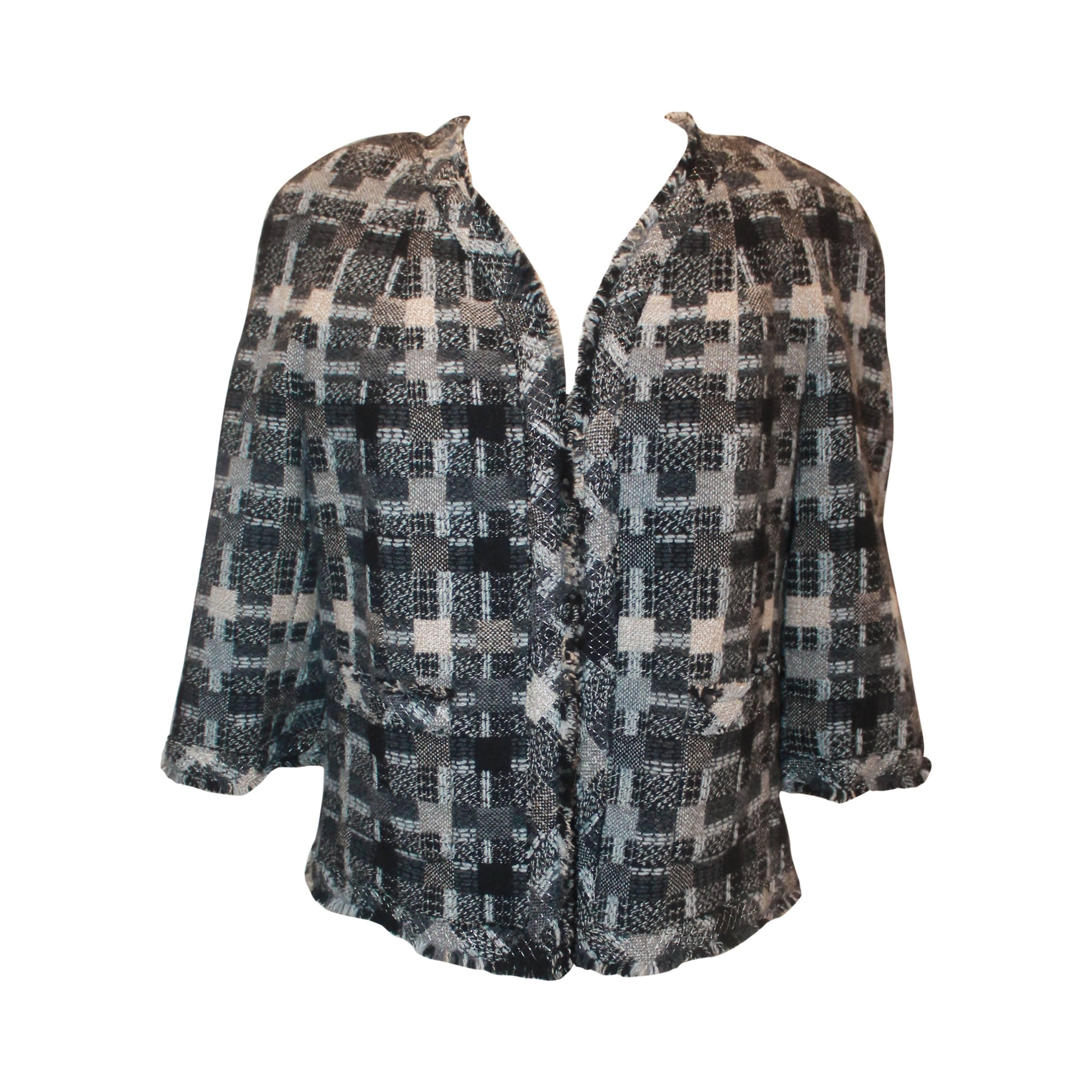 Chanel Vintage Fall 2005 Grey Tone Checkered Patterned 3/4 Sleeve Tweed Short Jacket - Size 42
This beautiful Chanel jacket is from the Fall 2005 Collection and is in excellent vintage condition. The short jacket is open with no front closures, has