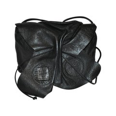 Bolso de hombro con cordón de piel de becerro texturizada negra Carlos Falchi Signature