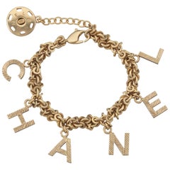 2003 Chanel Gold Tone Link Charm Bracelet Spelling C-H-A-N-E-L In Charms  at 1stDibs