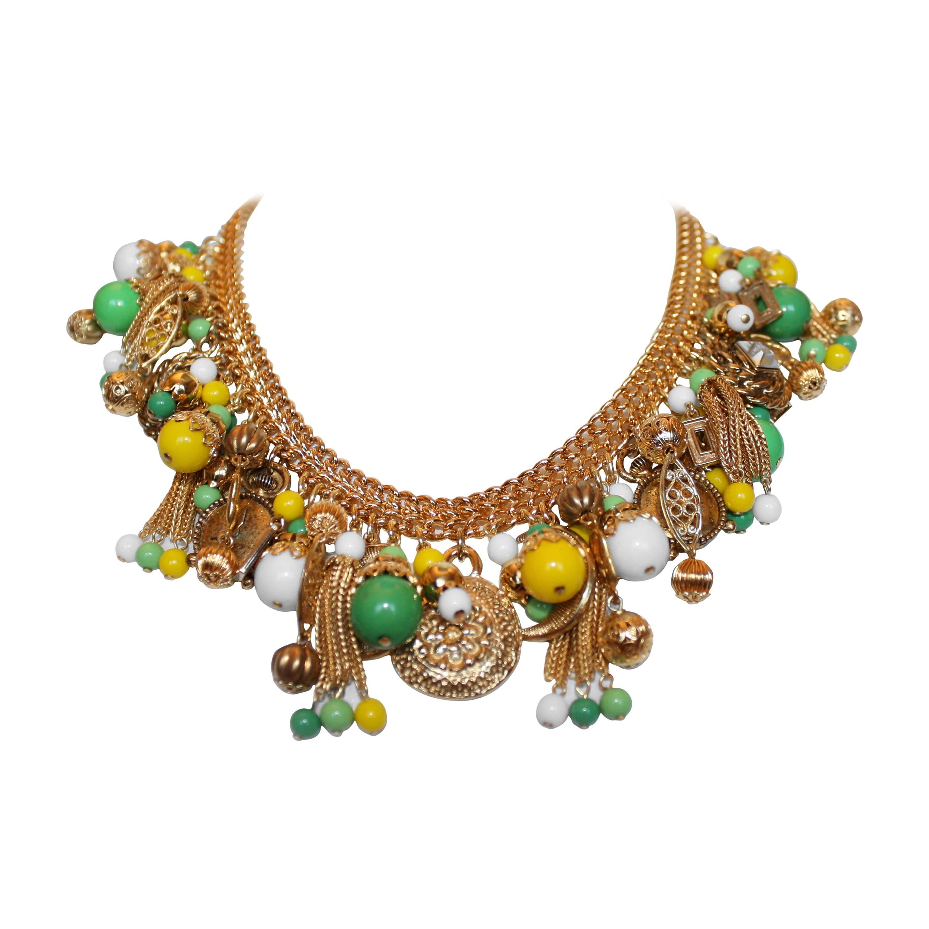 Collier tour de cou Françoise Montague composé de breloques en perles de verre vertes, jaunes et blanches faites à la main sur un traitement métallique doré. Le summum du luxe.

15