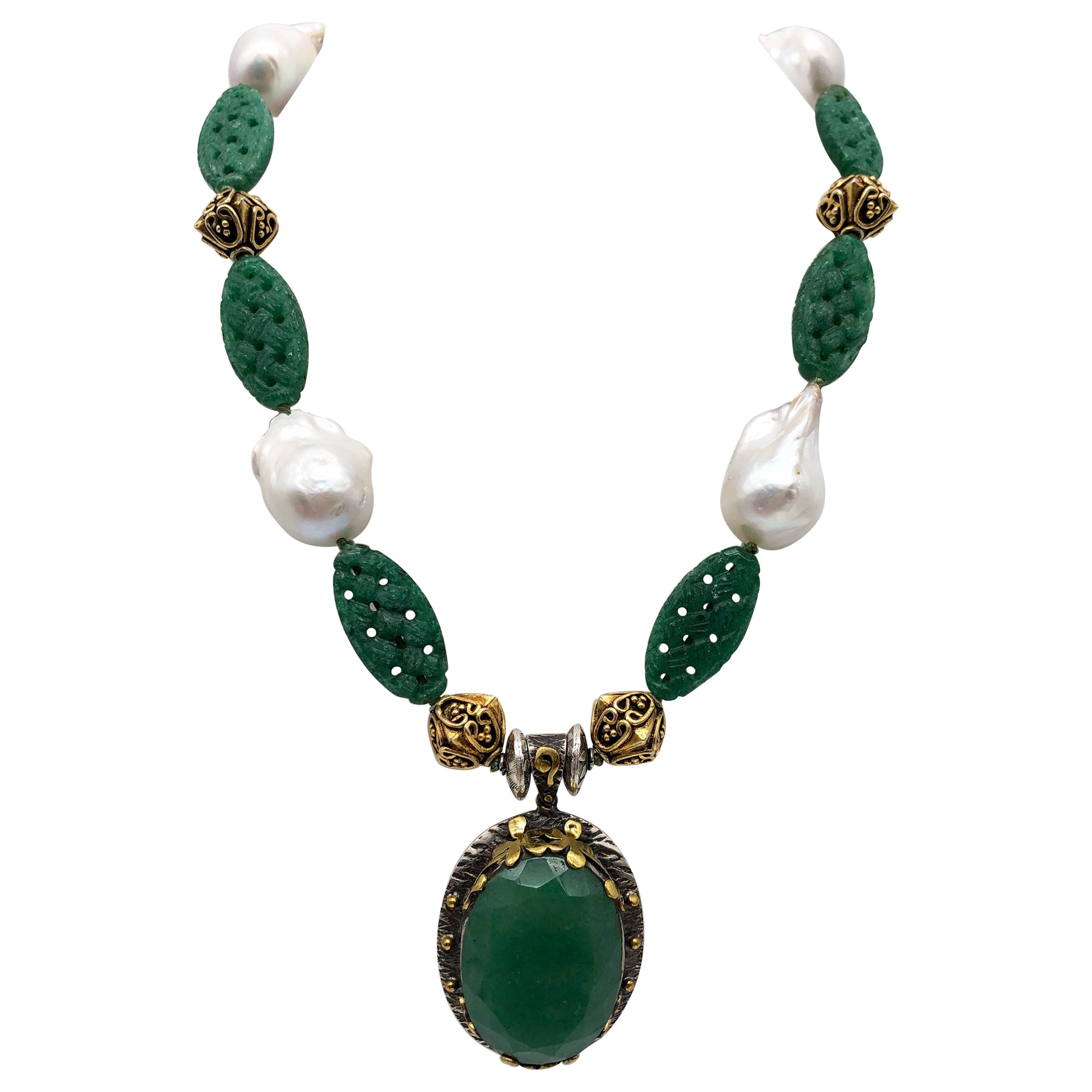 One-of-a-Kind

Handcrafted polished large Aventurine pendant created by Bora in an ornate sterling and brass frame. Suspended from an elegant necklace of carved Aventurine, ornate vermeil beads, and large lustrous Baroque Pearls. A clever set of