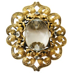 A large gilt metal Baroque brooch with large central stone, Joseff Of Hollywood.