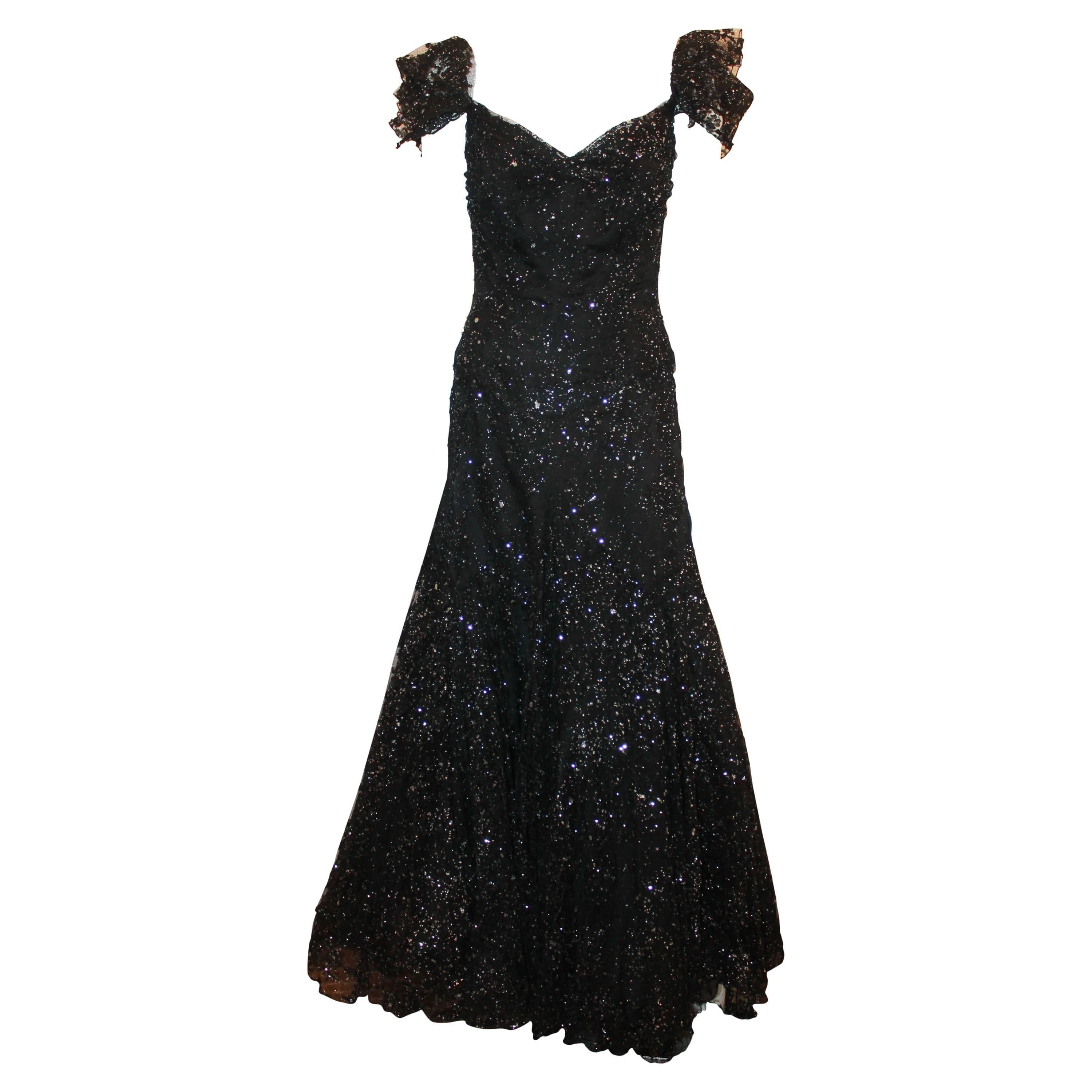 Vicky Tiel Black and Silver Tulle Lace Off the Shoulder Gown - 42.  This gorgeous gown is in excellent condition.  It features a gorgeous black tulle with silver accents, a built-in corset to the hips, an adjustable elastic ruffle strap, and a flare