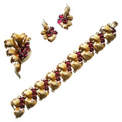 Gilt metal, ruby and clear paste bracelet, brooch and earrings, Boucher, 1960s