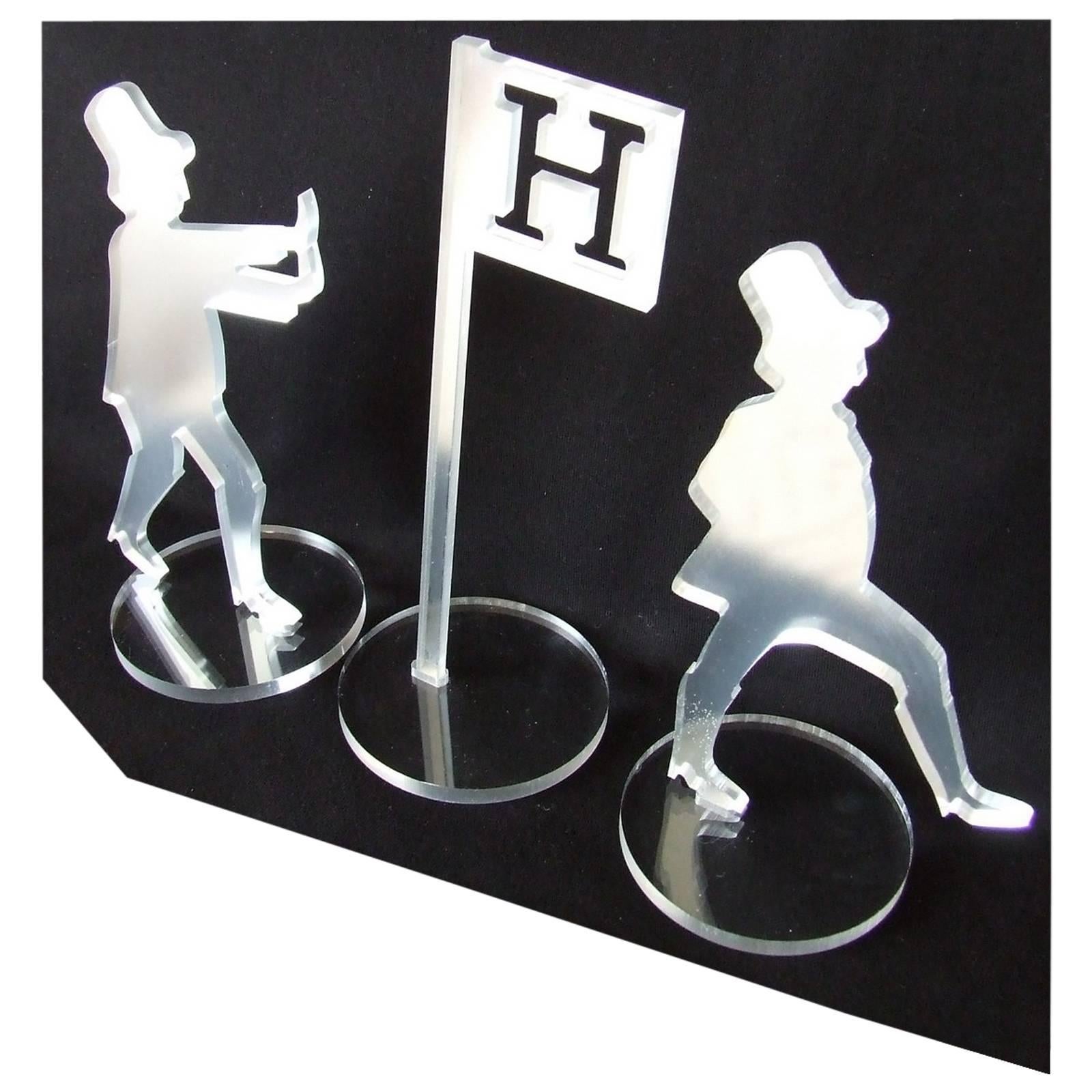RARE: 3 Figurines used to decorate a Hermès Shop Window 

Made of Plexiglas

Mirror effect (but are not mirrors)

Hooks on the back of the two characters

Settle on round bases in Plexiglas

Characters: around 18 cm Height (7 inches) / 10