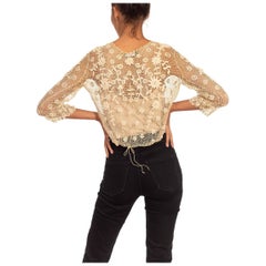 Top vittoriano all'uncinetto in cotone color crema con maniche lunghe