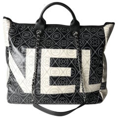 Chanel Shopper aus beschichtetem Segeltuch und Leder mit Kamelie und CC-Druck in Schwarz und Beige